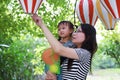 Mother mom embrace hug her daughter smile laugh have fun enjoy free time in summer park happy child childhood play with balloon Royalty Free Stock Photo