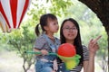 Mother mom embrace hug her daughter smile laugh have fun enjoy free time in summer park happy child childhood play with balloon Royalty Free Stock Photo