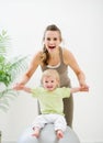 Mother mother holding baby sitting on fitness ball Royalty Free Stock Photo