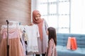 mother muslim choosing a dress for her daughter at clothing store