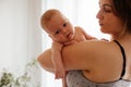 Mother with naked newborn on lighted white background