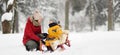 Mother/nanny talk with small child during sledding in winter park Royalty Free Stock Photo