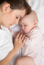 Mother with newborn baby sleeping on the bed at home. Top view, close up. Royalty Free Stock Photo