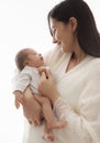 Mother with Newborn. Happy Mom hugging Baby. Happy Woman holding one Month little Child in Hands over White. Parent playing with Royalty Free Stock Photo