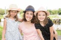 Mother outdoor nportrait with two girls daughter with straw hat near lake river in spring Royalty Free Stock Photo