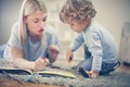 Mother painting book with her little son. Royalty Free Stock Photo