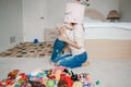 Mother parent playing with baby toddler in bedroom. Mom and kid boy girl with toy bin ontheir heads. Family having fun at home. Royalty Free Stock Photo
