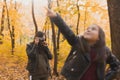 Mother photographer takes pictures of a her daughter in the park in autumn. Hobbies, photo art and leisure concept. Royalty Free Stock Photo