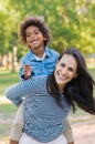 Mother piggybacking son at park Royalty Free Stock Photo