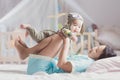 Mother play with her baby after walkup on the bed in bedroom