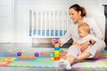 Mother build pyramid with baby boy in nursery