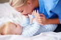 Mother Playing With Baby Son As They Lie In Bed Together Royalty Free Stock Photo