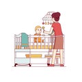 Mother playing with baby son sitting in crib bed Royalty Free Stock Photo