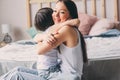 Mother playing with child son in bedroom. Happy family wearing pajamas Royalty Free Stock Photo