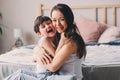 Mother playing with child son in bedroom. Happy family wearing pajamas Royalty Free Stock Photo