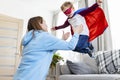 Mother playing with child in superhero costume. Indoor leisure activity concept. Royalty Free Stock Photo