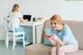 mother playing console game while her daughter working with laptop blurred Royalty Free Stock Photo