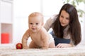 Mother playing with creeping on floor baby