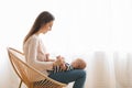 Mother playing with her baby while sitting in wicker chair Royalty Free Stock Photo