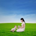 Mother playing with her baby in spring green field Royalty Free Stock Photo