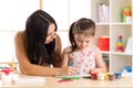 Mother playing with her child daughter, drawing together Royalty Free Stock Photo