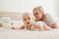 Mother playing with her newborn baby son at home. Family having fun sitting on bed in bedroom. Mother's day Royalty Free Stock Photo