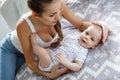 Mother playing with her newborn son lying on bed Royalty Free Stock Photo