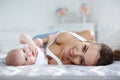 Mother playing with her newborn son lying on bed Royalty Free Stock Photo