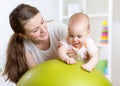 Mother plays with baby on fit ball Royalty Free Stock Photo