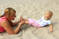 Mother plays with her baby plays on the sand Royalty Free Stock Photo