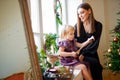 Mother plays with her daughter in dress.