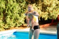 A mother plays with her little daughter in the pool. Summertime