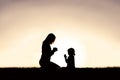 Mother Praying with her Young Child Outside at Sunset
