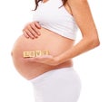 Mother, pregnancy and blocks with love in studio for care, support and future child. Pregnant woman, belly and holding Royalty Free Stock Photo
