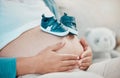 Mother with pregnant stomach in hands, shoes for baby with pregnancy, relax and waiting for birth with love and hope for Royalty Free Stock Photo
