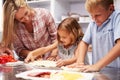 Mother preparing pizza with kids Royalty Free Stock Photo