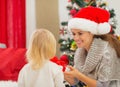 Mother presenting baby girl Christmas present Royalty Free Stock Photo