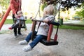 Mother Pushing Her Baby`s Having Fun on Swing Royalty Free Stock Photo