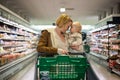 Mother pushing shopping cart with her infant baby boy child down department aisle in supermarket grocery store. Shopping Royalty Free Stock Photo