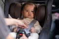 Mother put cute baby to car seat and secure with safety belts. Asian infant baby sit in baby seat and looking around in car.mom