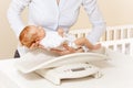 Mother put little newborn baby infant boy on scale Royalty Free Stock Photo
