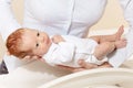 Mother put newborn baby infant boy to the scale Royalty Free Stock Photo