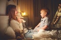 Mother puts the baby son to sleep in evening in bed Royalty Free Stock Photo