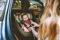 Mother putting baby in safety car seat family lifestyle Royalty Free Stock Photo