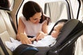 Mother Putting Baby Son Into Car Travel Seat Royalty Free Stock Photo