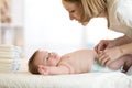 Mother putting diaper on her happy baby Royalty Free Stock Photo