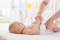 Mother putting diaper on her happy baby Royalty Free Stock Photo