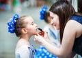 Mother putting lipstick on her daughter Royalty Free Stock Photo