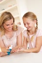 Mother putting sanitizer on young girl's hands