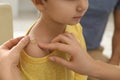 Mother putting sticking plaster onto son`s shoulder, closeup